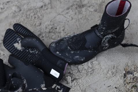 ION Ballistic Boots 3/2 neoprene split-toe boots in black during kitesurfing on sandy beach