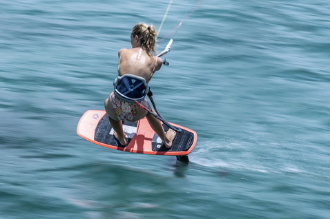 ION Nova waist harness in steel blue during kitesurfing on the ocean