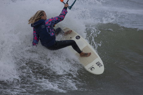 ION Neo Hoody Lite sweat à capuche femme en bleu marine et rose lors du kitesurf sur l'océan