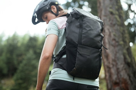 ION Scrub 14 backpack in black during mountain biking in the forest