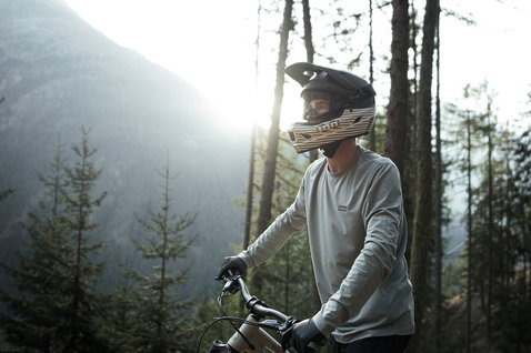 ION Scrub Amp fullface helmet during mountain biking in mountain forest in charcoal and off-white