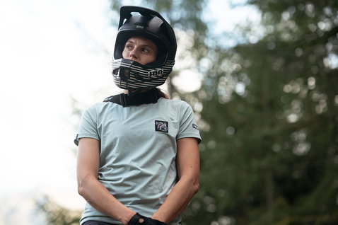 ION Seek Amp SS women cycling jersey in sage green during mountain biking in the forest
