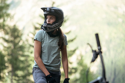 ION Seek Amp SS women cycling jersey in sage green during mountain biking on a forest trail