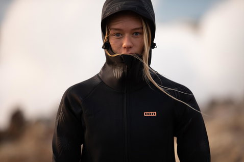 Veste néoprène à capuche ION Neo Cosy Coat Core femme en noir portée en bord de mer