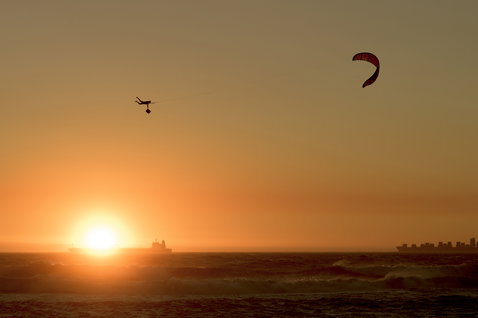 ION Seek Amp combinaison 5/4mm zip dos pendant le kitesurf au coucher du soleil