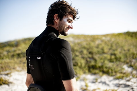ION Protection Suit combinaison néoprène 3/2mm zip frontal manches courtes en noir sur dunes côtières