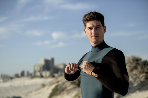 ION Seek Amp 4/3mm front-zip fullsuit in teal and black worn on the beach