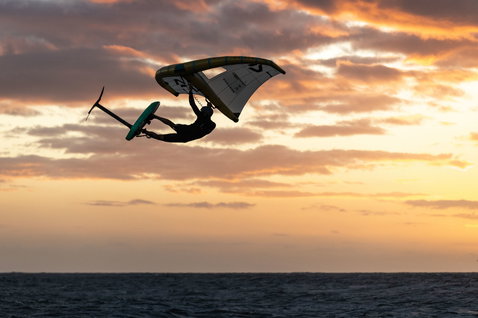 ION Element 2/2mm Langarm-Shorty Backzip Neoprenanzug beim Wing Foiling im Sonnenuntergang