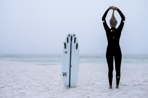 ION Amaze Core 5/4 Front-Zip Neoprenanzug in schwarz beim Wellenreiten am Strand