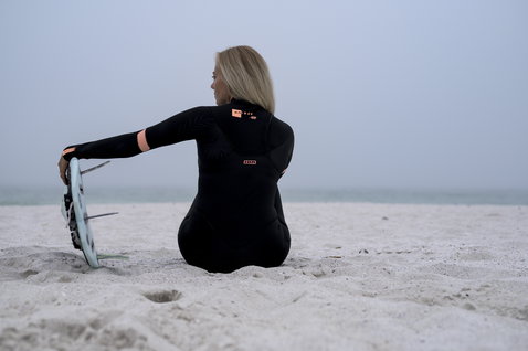 ION Amaze Core 5/4mm Frontzip Neoprenanzug in schwarz beim Kitesurfen am Strand