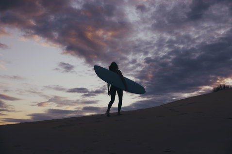 ION Amaze Shorty 2.5mm back-zip shorty wetsuit during wave riding at the beach at dusk