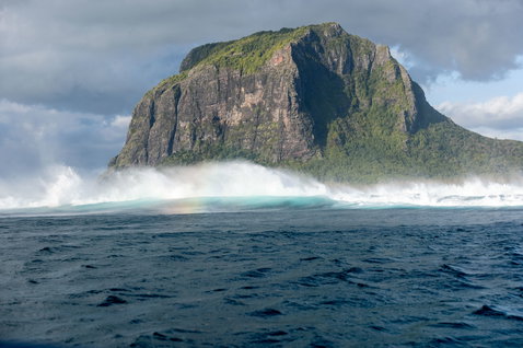 ION Vega seat harness lifestyle shot with dramatic breaking waves and volcanic island in Mauritius