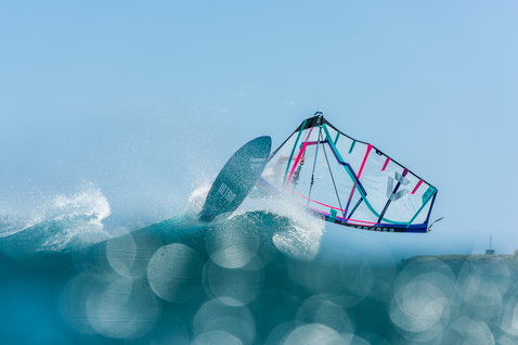 Duotone Super Hero HD Freestyle Windsurf-Segel in petrol, pink und cyan beim Windsurfen auf dem Meer