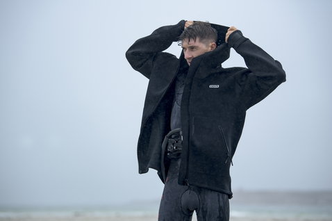 Veste en néoprène ION Neo Shelter Core en noir lors du kitesurf sur la plage