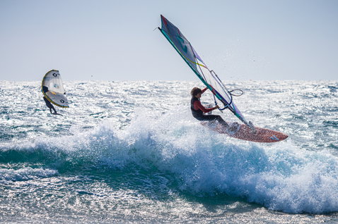 ION Capture 4/3mm back-zip junior fullsuit in navy blue during windsurfing on the ocean