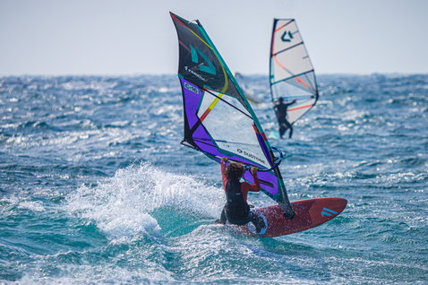 ION Capture 5/4mm back-zip fullsuit in dark navy during windsurfing on the ocean