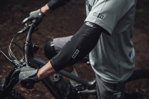 ION E-Sleeve Amp elbow pads in black during mountain biking in forest trail