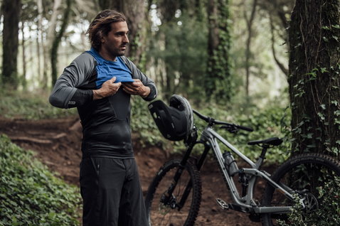 Gilet de protection ION Scrub Amp en gris anthracite lors du VTT en forêt