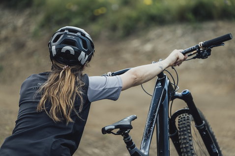 ION Scrub Amp SS women cycling jersey in black and grey during mountain biking on trail