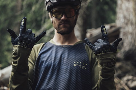 ION Scrub Langarm-Radtrikot Herren in dunkelgrau und olivgrün beim Mountainbiken im Wald