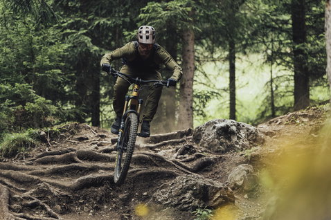 ION Bike Scrub LS Langarm MTB Trikot in olive beim Mountainbiken im Bergwald