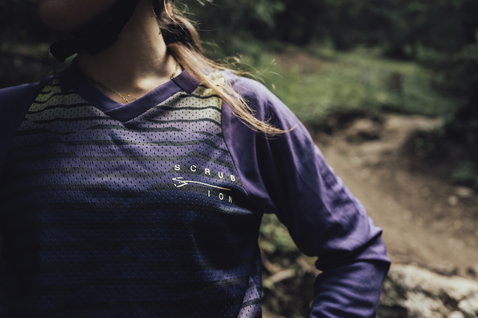 ION Scrub women's long-sleeve MTB jersey in dark purple during mountain biking on forest trail