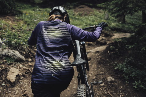 ION Scrub LS women cycling jersey in purple during mountain biking on a forest trail