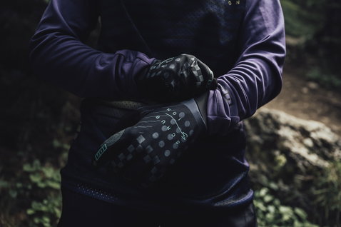 ION Scrub full-finger bike gloves in black during mountain biking in a forest