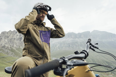 ION Shelter 2L Softshell Jacke in olive und lila beim Mountainbiken in den Alpen