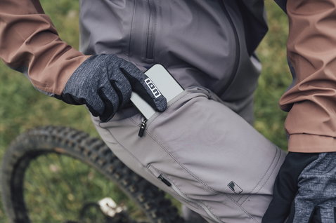 ION Shelter 3L Mountainbike-Hose in steingrau beim Trailfahren, Hüfttasche mit Reißverschluss