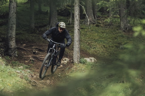 ION Shelter Anorak 2.5L cycling jacket in black during mountain biking in the forest