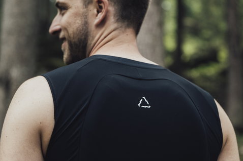 Gilet protettivo ION Bike Amp con paraschiena SAS-TEC L1 in nero durante mountain bike in foresta