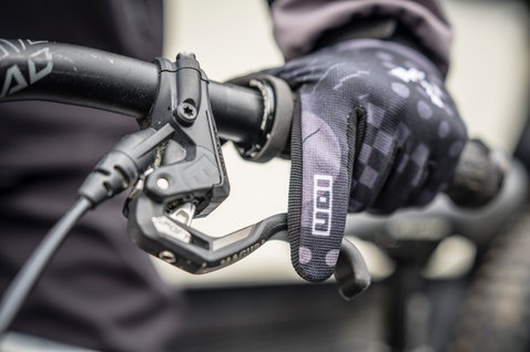 ION Scrub Youth full-finger bike gloves in black during mountain biking on trail