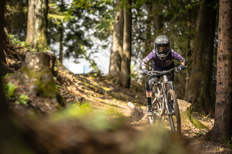 ION Scrub SS youth cycling jersey in purple during mountain biking in forest trail