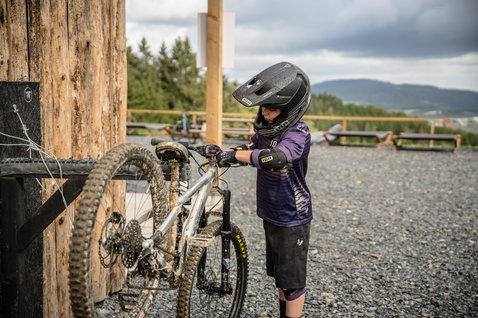 ION Scrub SS youth MTB jersey in purple and charcoal during mountain biking at a bike park