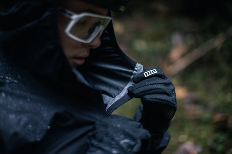 ION Shelter 2.5L anorak in black during mountain biking in rainy forest conditions