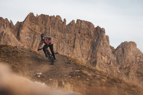 ION Bike Shelter 3L Herren Jacke in dusty brown beim Mountainbiken auf alpinem Trail