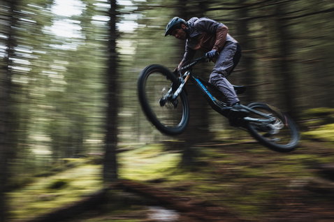 ION Bike Shelter 3L Herren Hardshelljacke in dunkelgrau beim Mountainbiken im Wald
