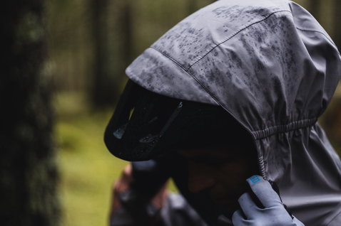 ION Bike Shelter 3L Jacke Herren in grau und rosé beim Mountainbiken im Regenwald