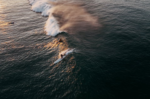 ION Amaze Hot Shorty fato shorty 1,5mm zip frontal durante surf no oceano ao pôr do sol