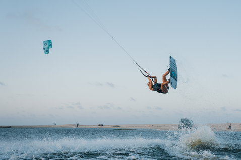 ION Amaze Shorty Crossback 1,5mm shorty pull-on em azul-acinzentado durante o kitesurf no mar