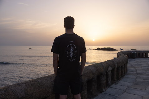ION Logo boardshorts 20" men in black during golden-hour at coastal promenade