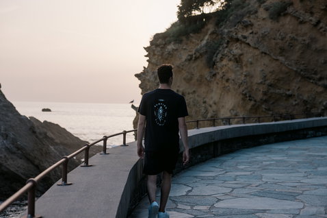 ION Bike Graphic SS men's t-shirt in black with back graphic print during a coastal walk at dusk
