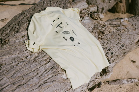ION Bike Vibes SS men's t-shirt in cream white with graphic print, flat-lay on driftwood