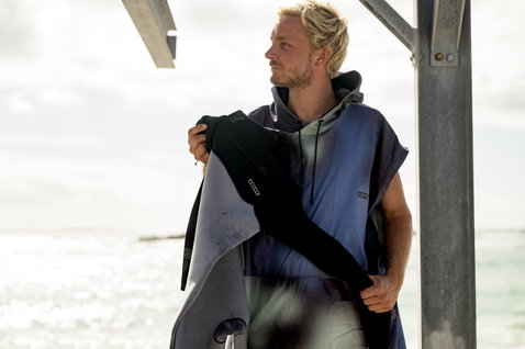 ION Poncho Select homem durante kitesurf no oceano em cinzento escuro com capuz