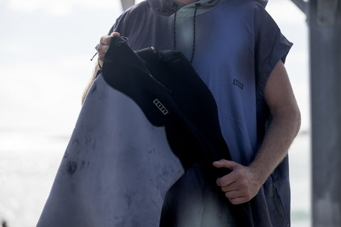 ION Poncho Select homem poncho de mudança em azul-marinho escuro durante desportos aquáticos na costa