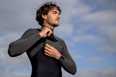 ION Seek Amp 4/3mm front-zip fullsuit during kitesurfing in dark charcoal and grey