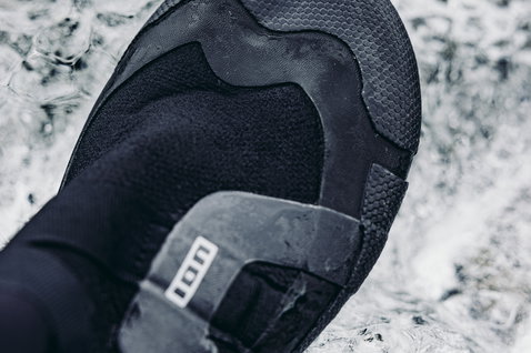 ION Ballistic Boots 3/2mm neoprene split-toe boots during kitesurfing on wet coastal rocks
