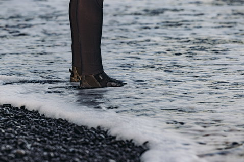 ION Ballistic Boots 3/2mm neoprene boots in black during kitesurfing in ocean surf
