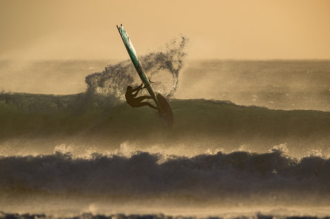Harnais de taille ION Rival lors de windsurf sur vagues en lumière dorée du soir